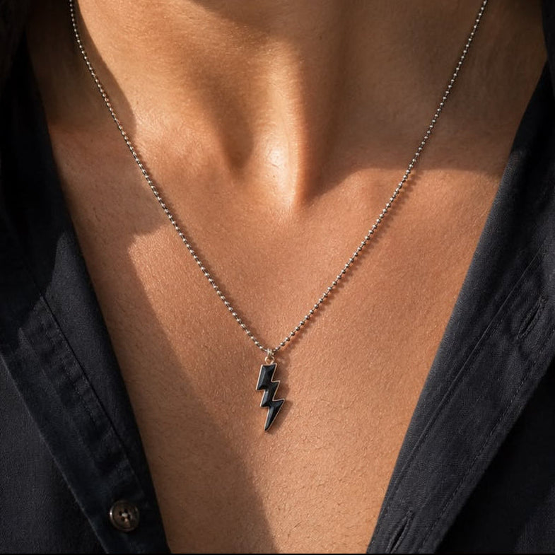 Herenhanger met bliksemmotief, zwart emaille en verguld zilver.